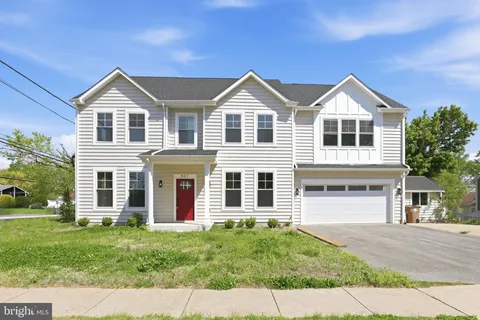 a view of a house with a yard and large tree