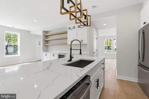 a kitchen with kitchen island stainless steel appliances a sink stove and refrigerator