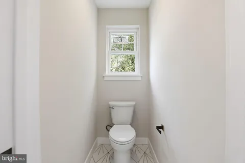 a white toilet sitting next to a window