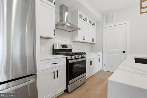 a kitchen with white cabinets and appliances