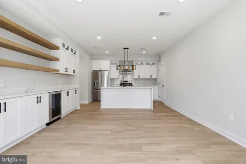 a view of kitchen with kitchen island a sink stainless steel appliances and cabinets