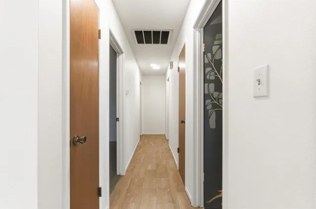 a view of a hallway with wooden floor