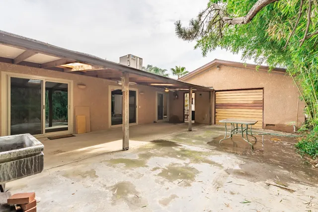 a view of a house with a patio and wooden fence