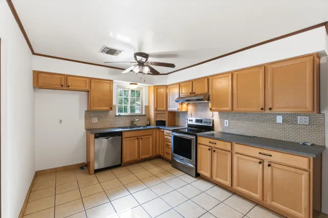 a kitchen with stainless steel appliances granite countertop a sink and stove top oven