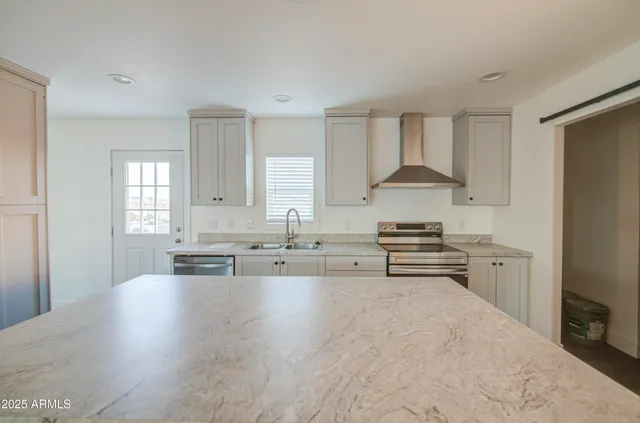 a kitchen with sink stove and refrigerator