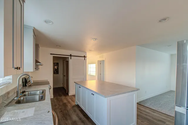 a kitchen with stainless steel appliances granite countertop a stove a sink and a refrigerator