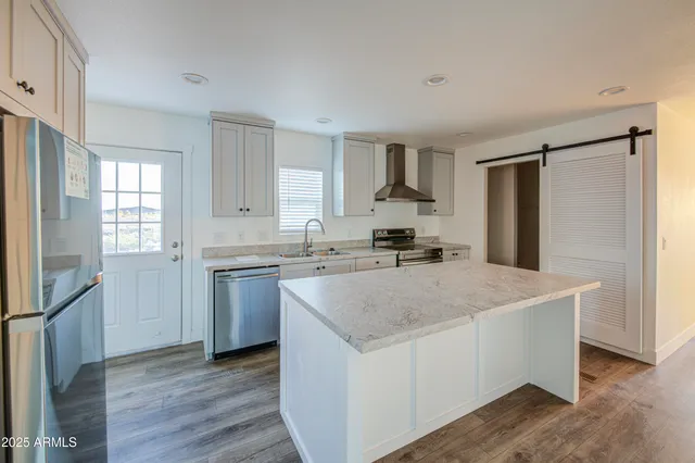 a kitchen with stainless steel appliances granite countertop a sink stove and refrigerator
