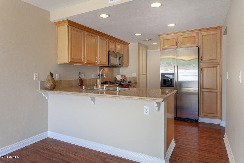 1990 Rory Lane, Unit 3 Simi Valley, CA 93063 - Photo 6 of 22 a kitchen with stainless steel appliances granite countertop a refrigerator a sink a stove a microwave and island with wooden floor