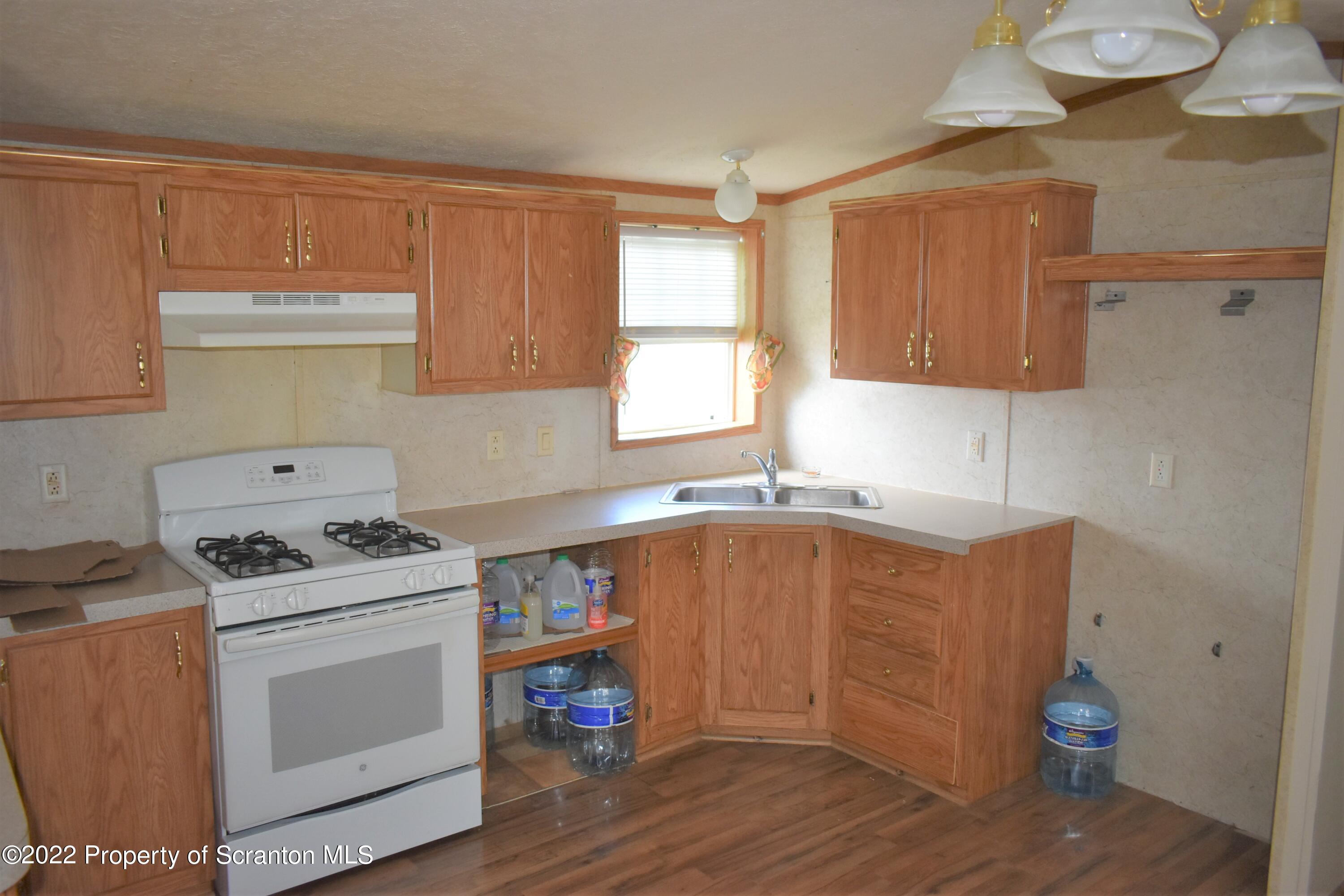 940 Nowlan Road Port Crane, NY 13833 - Photo 8 of 12 a kitchen with wooden cabinets and a stove top oven