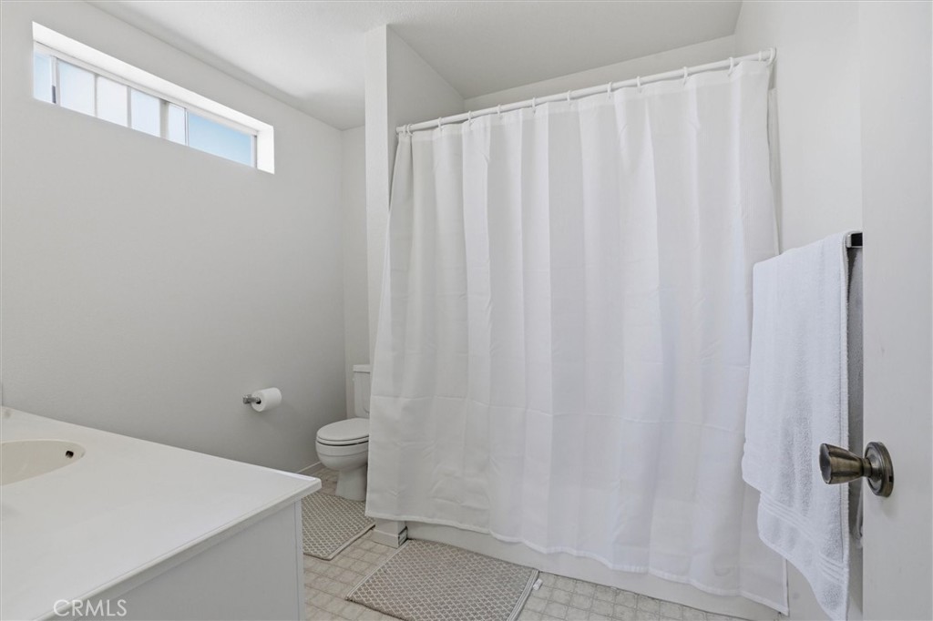2483 Country Santa Maria, CA 93455 - Photo 13 of 19 a bathroom with a shower curtain and a toilet