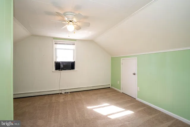 an empty room with a ceiling fan and window
