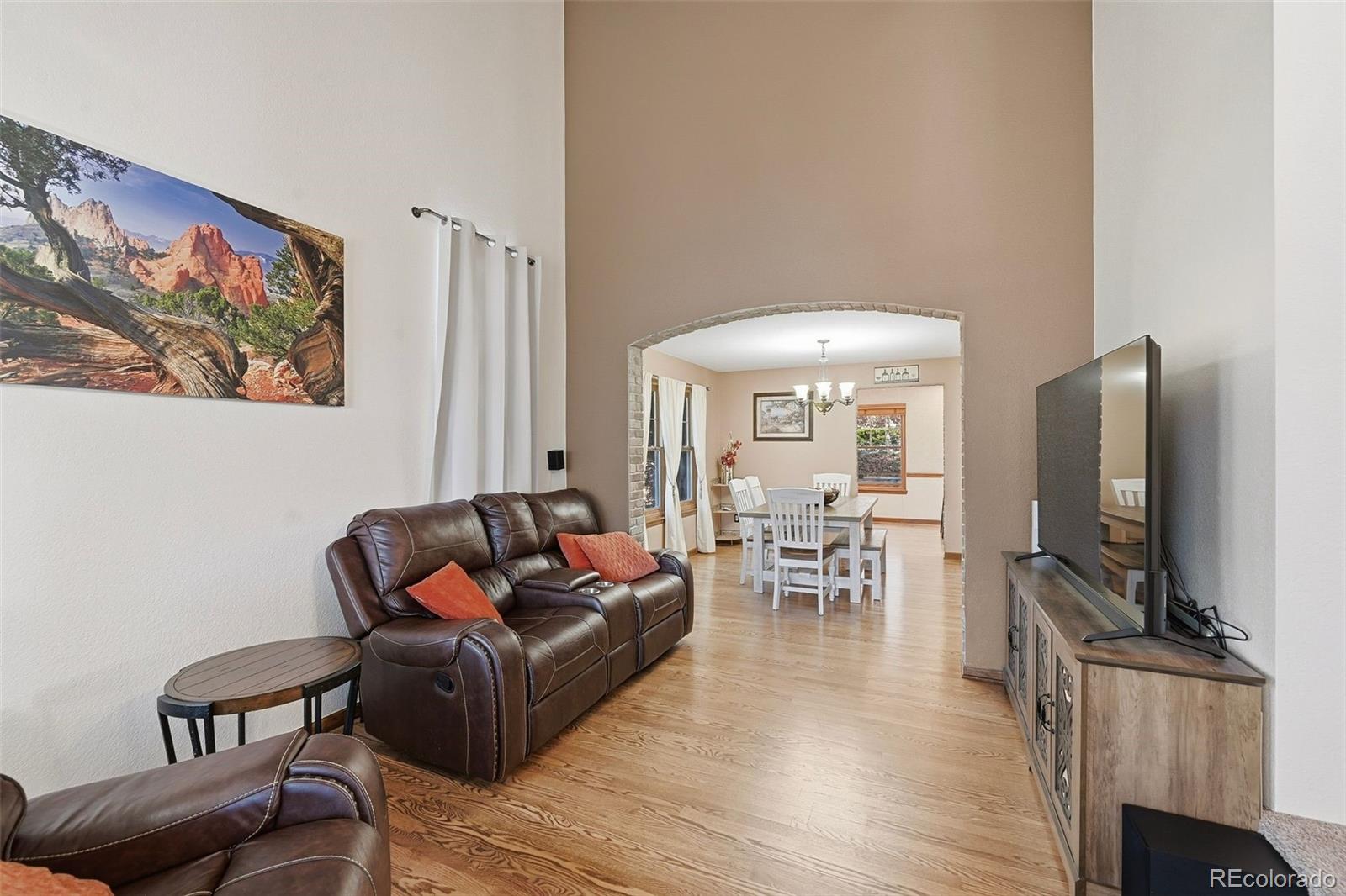 9372 Prairie View Drive Highlands Ranch, CO 80126 - Photo 23 of 50 a living room with furniture a wooden floor and a flat screen tv