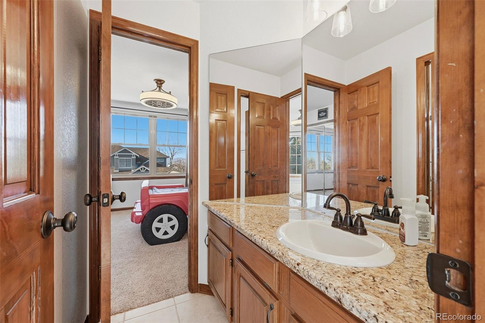 9372 Prairie View Drive Highlands Ranch, CO 80126 - Photo 34 of 50 a bathroom with a granite countertop sink and a mirror