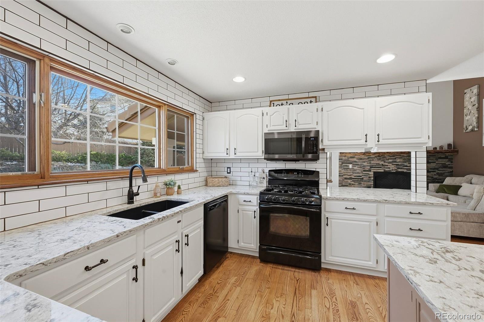 9372 Prairie View Drive Highlands Ranch, CO 80126 - Photo 5 of 50 a kitchen with granite countertop a sink stainless steel appliances and cabinets