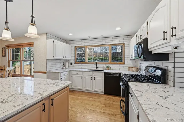 a kitchen with stainless steel appliances granite countertop a sink stove and wooden floor
