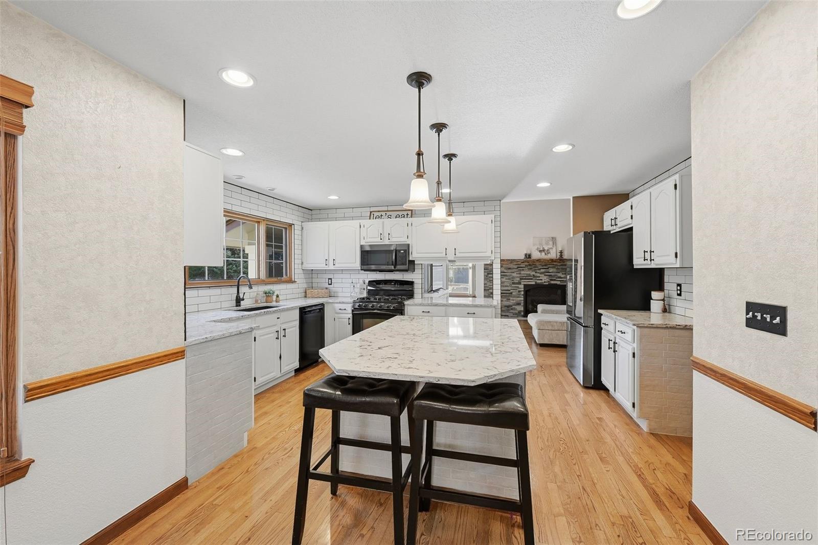 9372 Prairie View Drive Highlands Ranch, CO 80126 - Photo 8 of 50 a kitchen with a dining table chairs stainless steel appliances and cabinets
