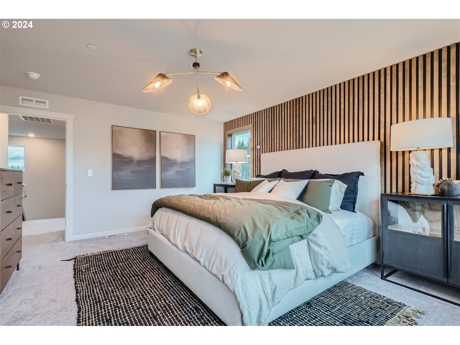 2735 South 9th Circle Ridgefield, WA 98642 - Photo 18 of 38 a bedroom with a large bed and a chandelier