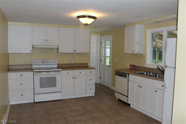 1438 Isler Circle Northwest Canton, OH 44708 - Photo 2 of 11 The kitchen has white cabinets and tile floors, and opens to the family room.