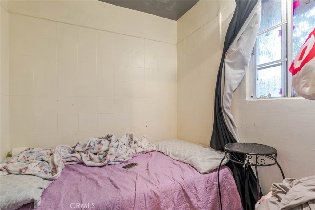 811 East 43rd Place Los Angeles, CA 90011 - Photo 24 of 31 a bedroom with a bed and a window
