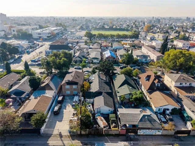 an aerial view of multiple houses with a city street