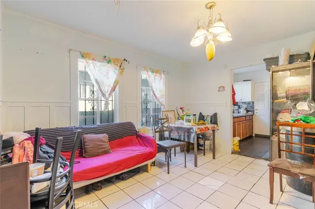 a living room with furniture a chandelier and a dining table