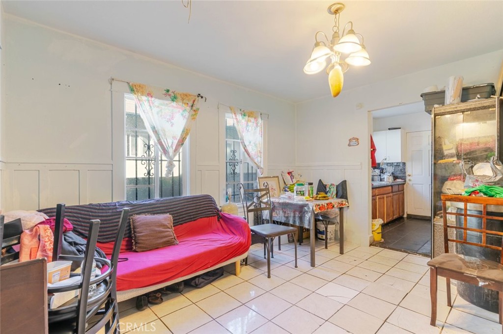 811 East 43rd Place Los Angeles, CA 90011 - Photo 5 of 31 a living room with furniture a chandelier and a dining table