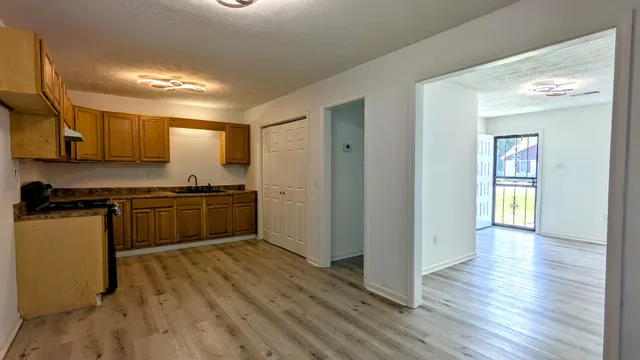 a kitchen with a refrigerator and a stove top oven