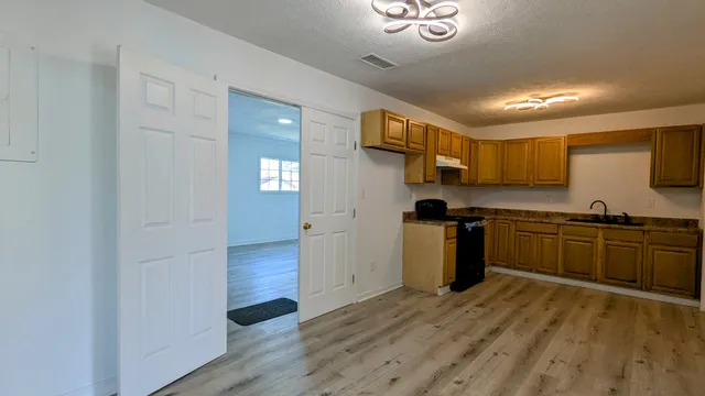 a kitchen with a refrigerator and a stove top oven