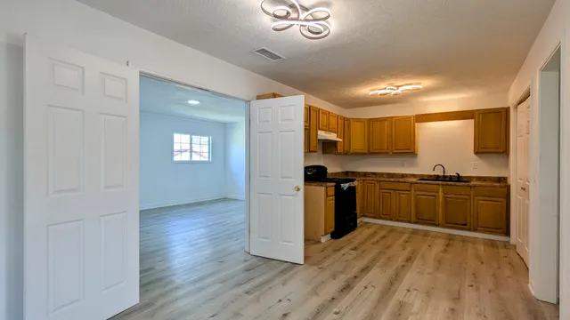 a kitchen with granite countertop a refrigerator and a stove top oven