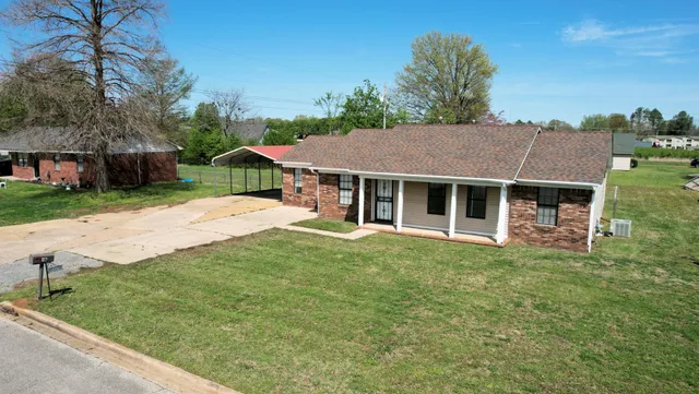 a house with green field in front of it