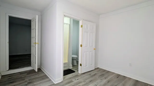 an empty room with wooden floor and closet