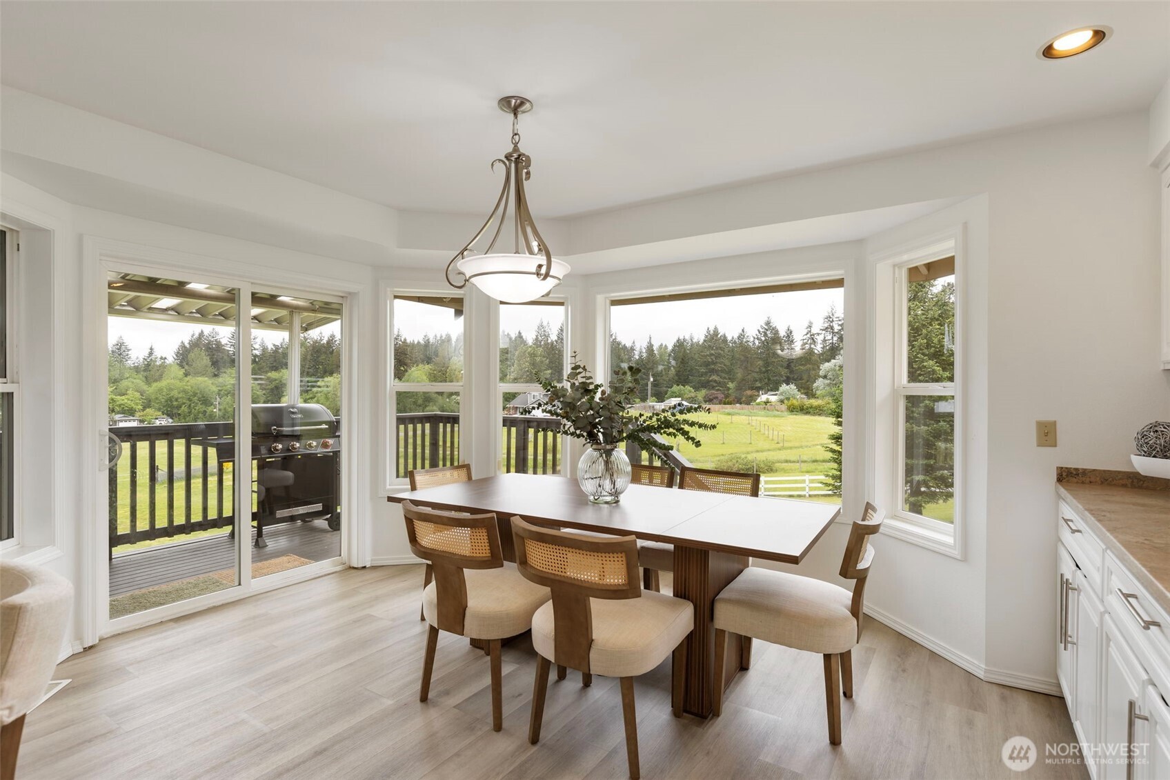 14110 Glenwood Road Southwest Port Orchard, WA 98367 - Photo 11 of 40 a view of a dining room with furniture large windows and wooden floor