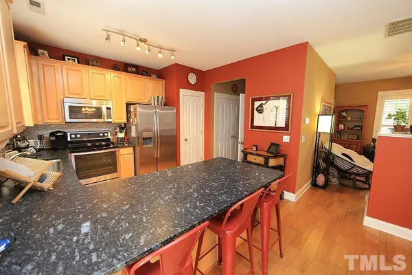 a kitchen with stainless steel appliances granite countertop a refrigerator a stove and a sink