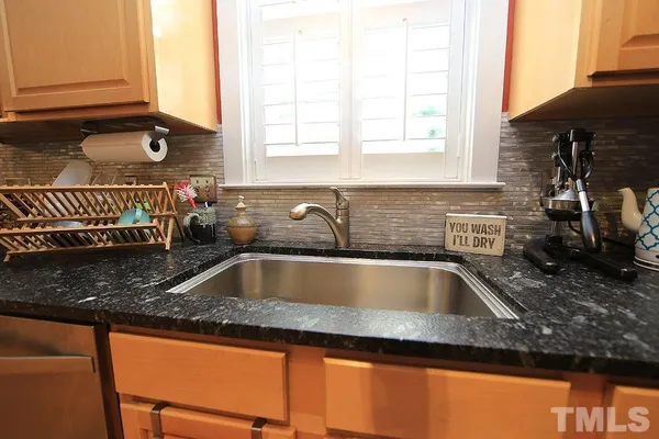 a kitchen with granite countertop sink and cabinets