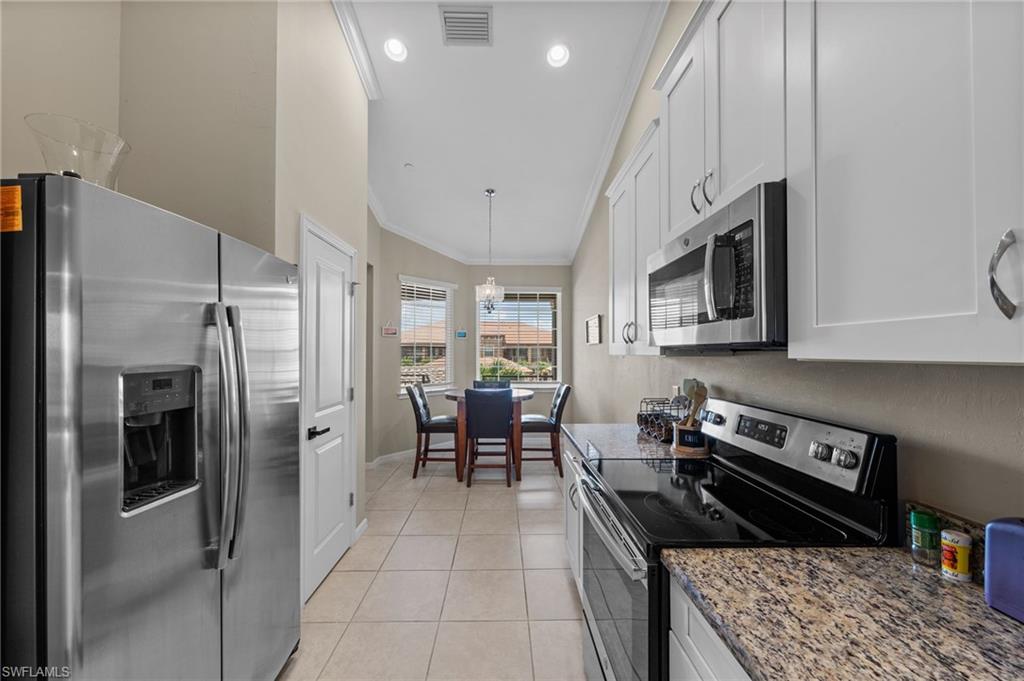 9366 Pocida Court, Unit 202 Naples, FL 34119 - Photo 10 of 44 a kitchen with stainless steel appliances granite countertop a refrigerator a stove and a sink