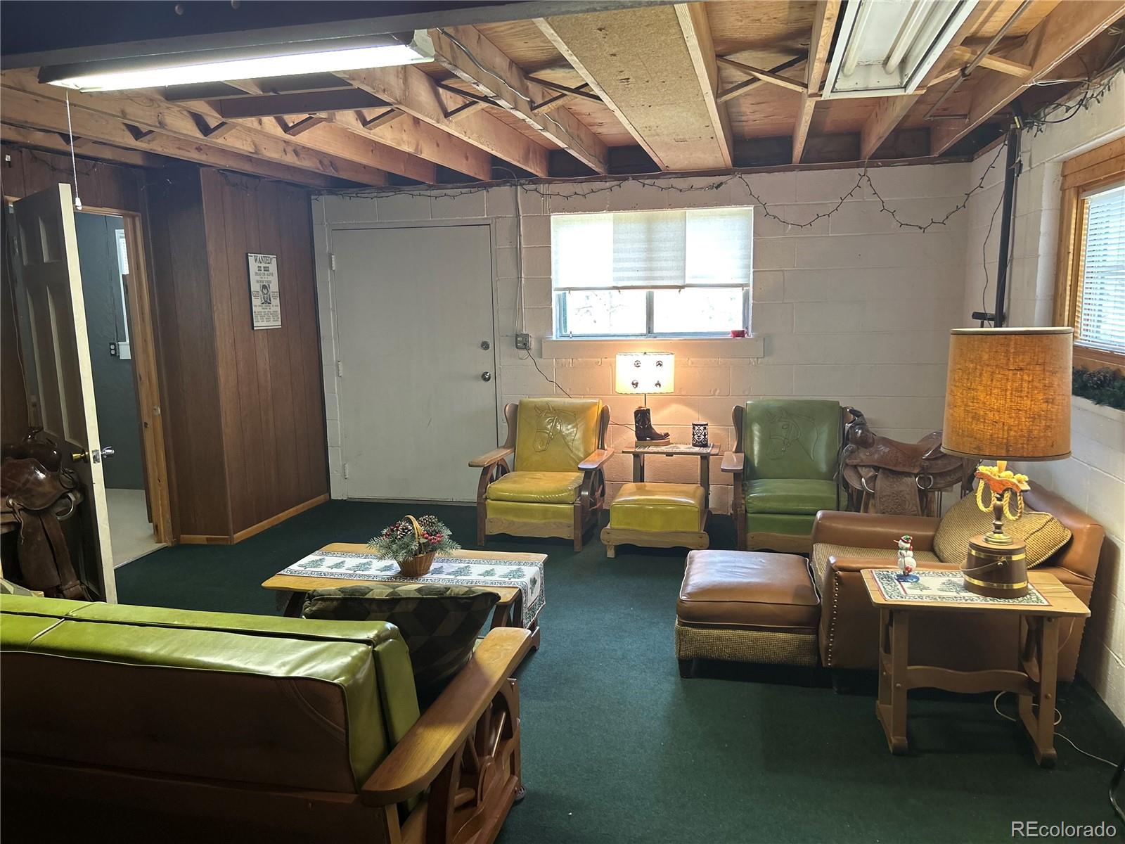 4393 South Pima Road Indian Hills, CO 80454 - Photo 11 of 12 a living room with furniture a flat screen tv and a table
