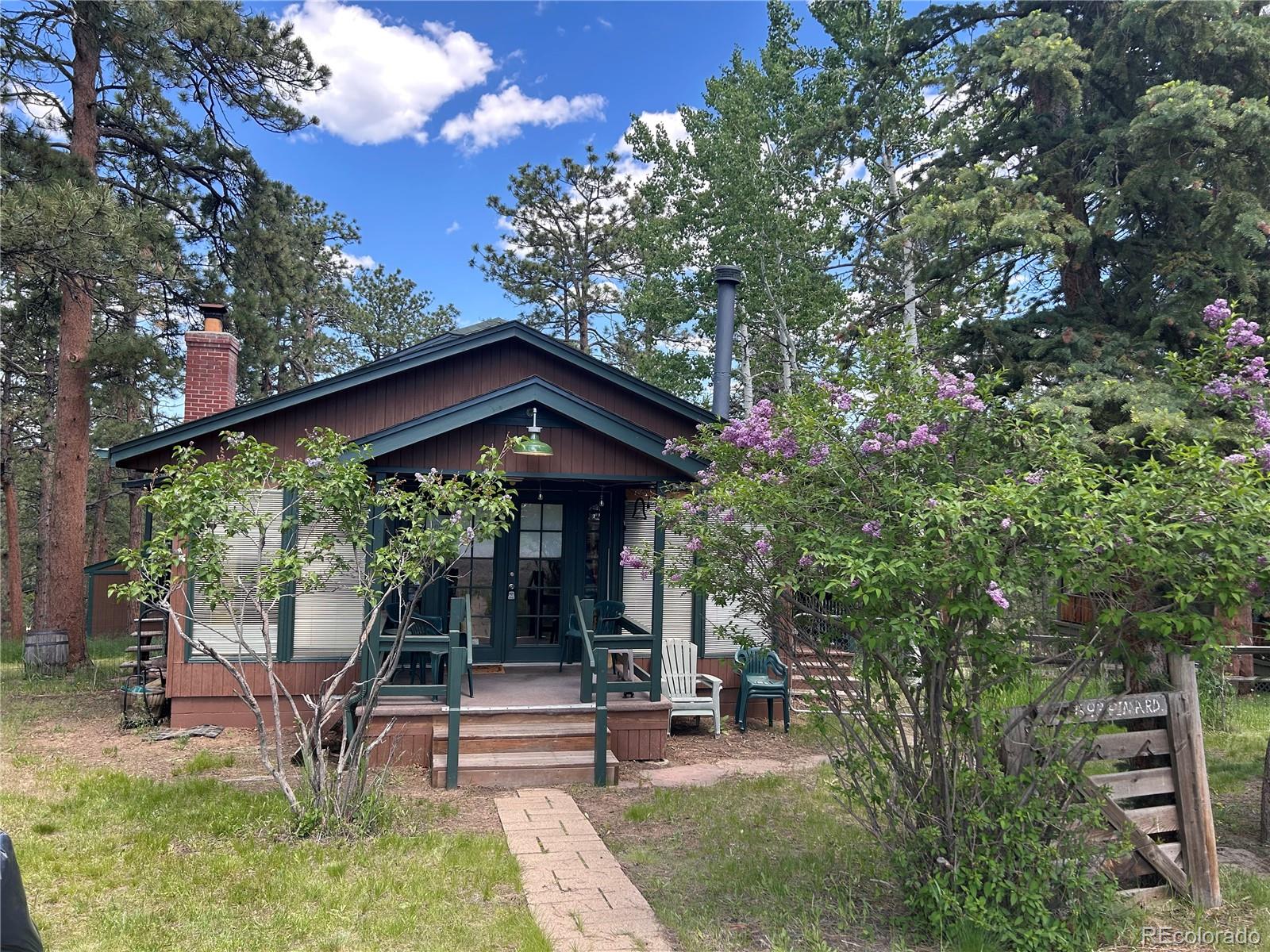 4393 South Pima Road Indian Hills, CO 80454 - Photo 3 of 12 a view of a patio with table and chairs under an umbrella