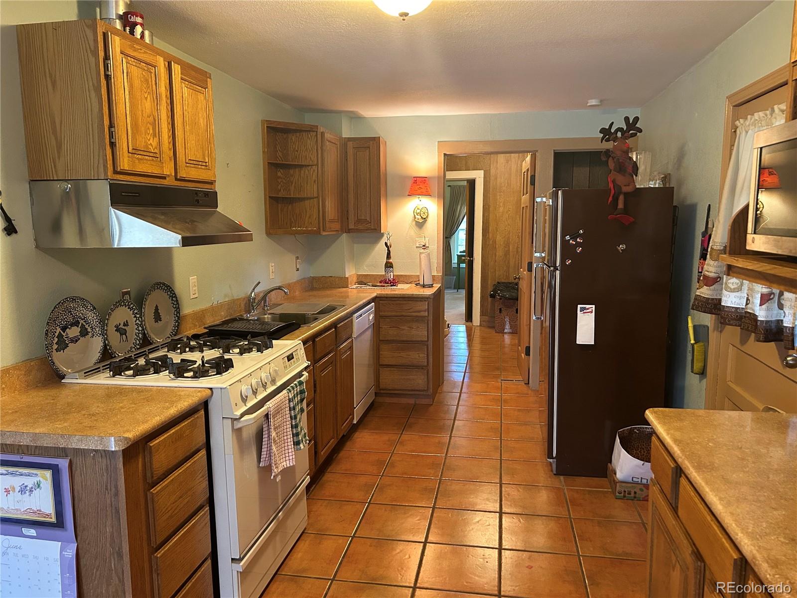 4393 South Pima Road Indian Hills, CO 80454 - Photo 5 of 12 a kitchen with a sink a stove and refrigerator