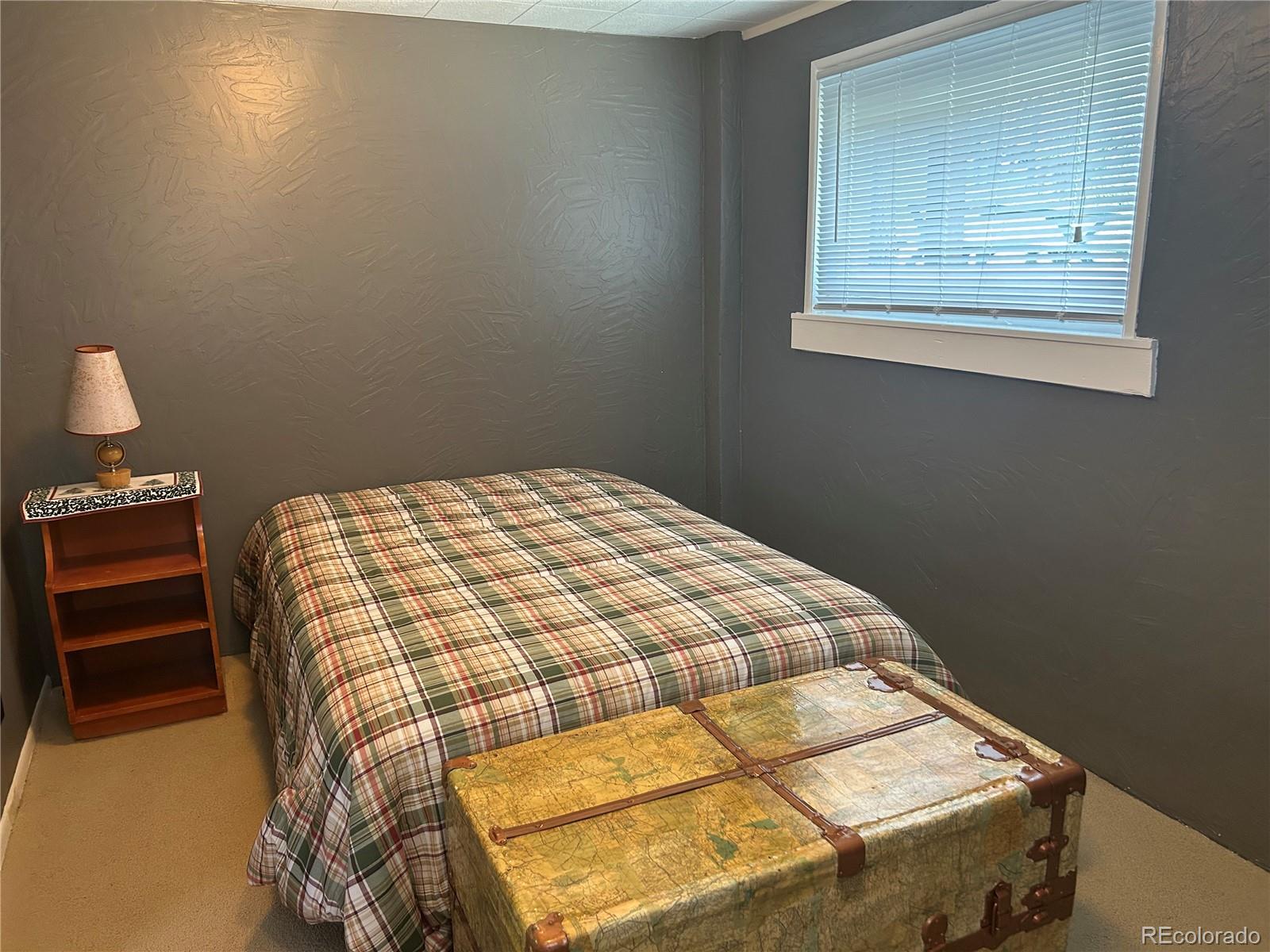 4393 South Pima Road Indian Hills, CO 80454 - Photo 9 of 12 a bedroom with a bed and a window