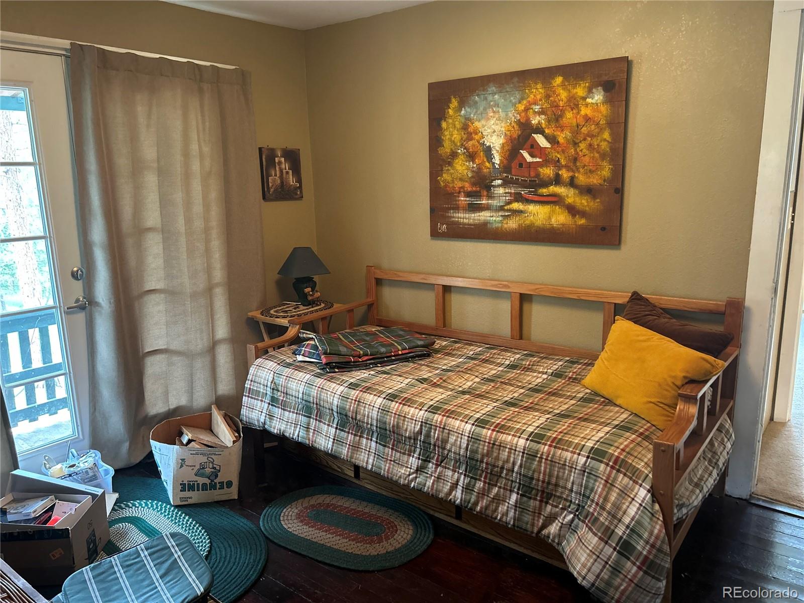 4393 South Pima Road Indian Hills, CO 80454 - Photo 10 of 12 a bedroom with a bed and wooden floor