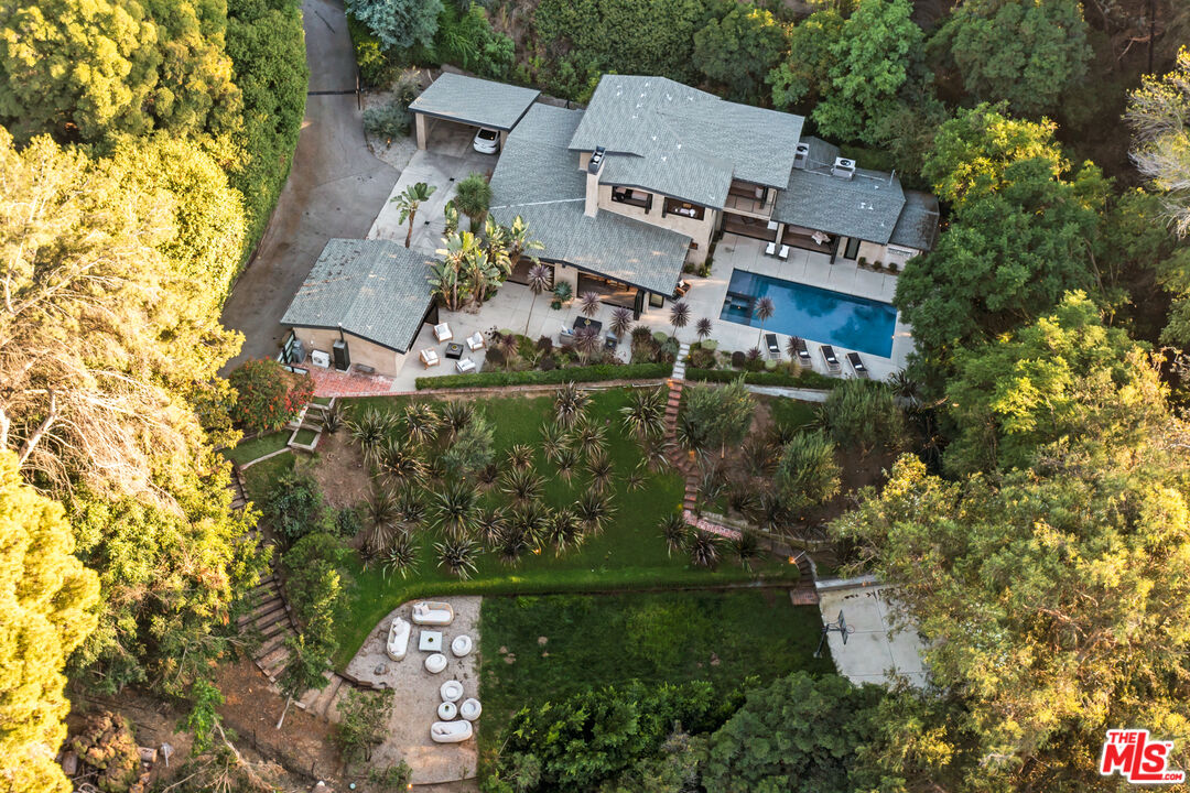 an aerial view of a house with a yard swimming pool and outdoor seating