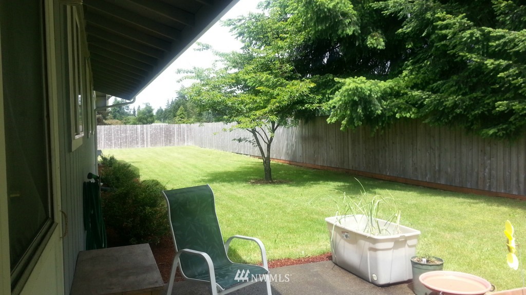 8440 178th Avenue Southwest Rochester, WA 98579 - Photo 14 of 15 a view of a backyard with table and chairs potted plants and tree