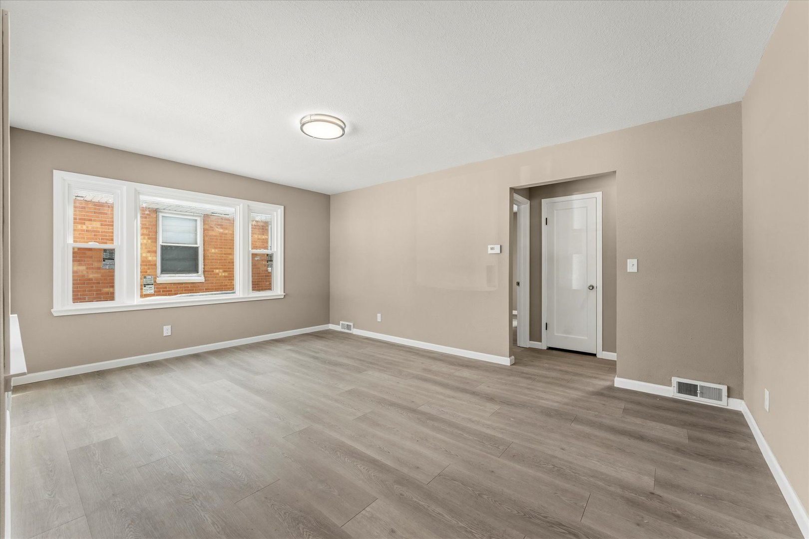 1407 West Clark Street Champaign, IL 61821 - Photo 6 of 28 a view of an empty room with window and wooden floor