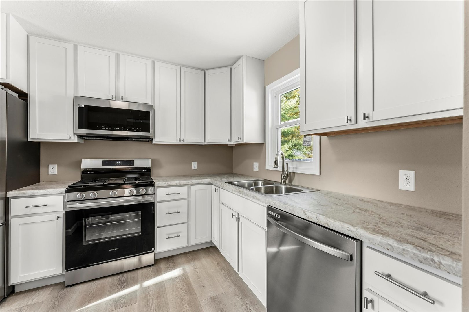 1407 West Clark Street Champaign, IL 61821 - Photo 10 of 28 a kitchen with granite countertop a stove a sink and a microwave