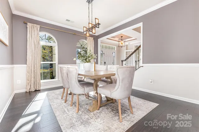 a dining room with furniture a chandelier and wooden floor