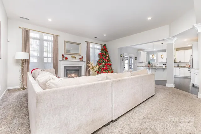 a living room with furniture a fireplace and a kitchen view