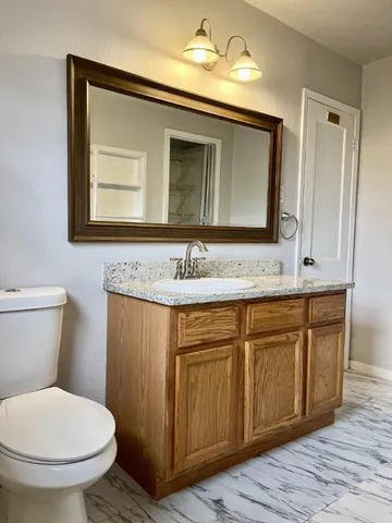 a bathroom with a toilet sink and mirror