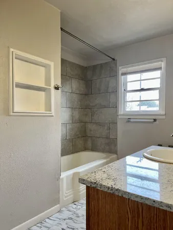 a bathroom with a granite countertop sink a toilet and shower