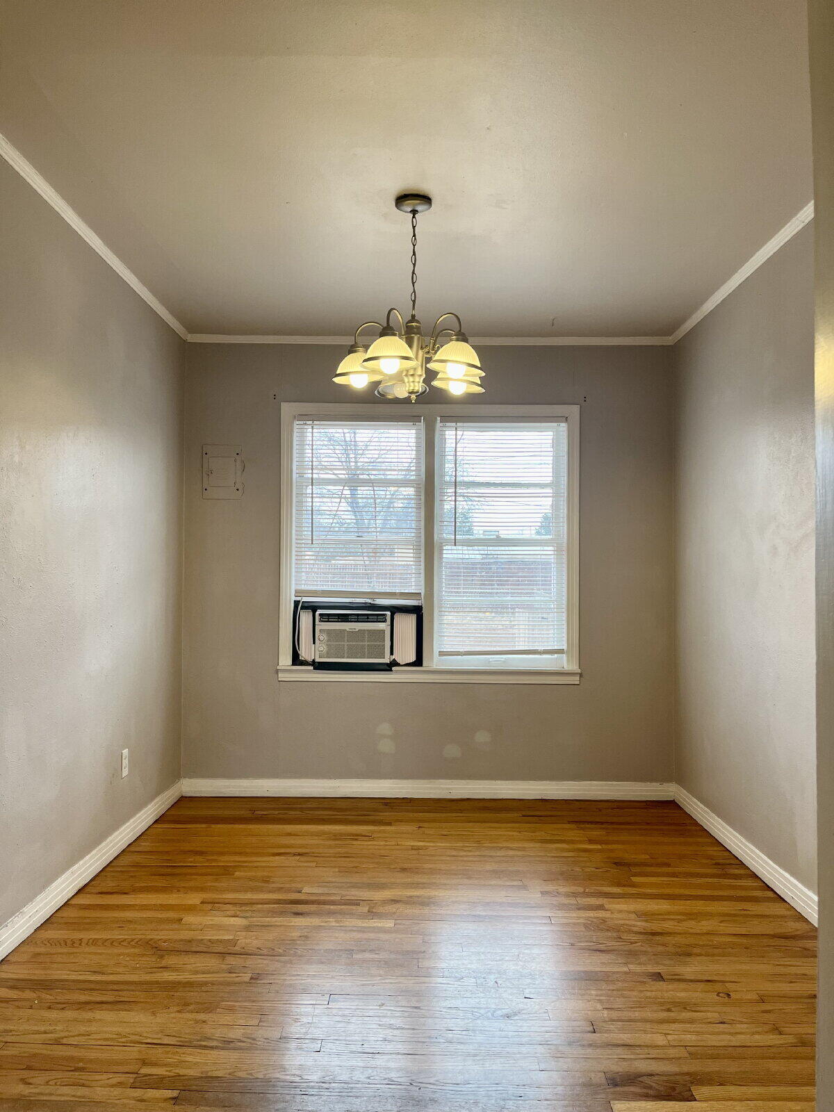 3414 24th Street, Unit FRONT Lubbock, TX 79410 - Photo 5 of 21 a view of an empty room with wooden floor and a window