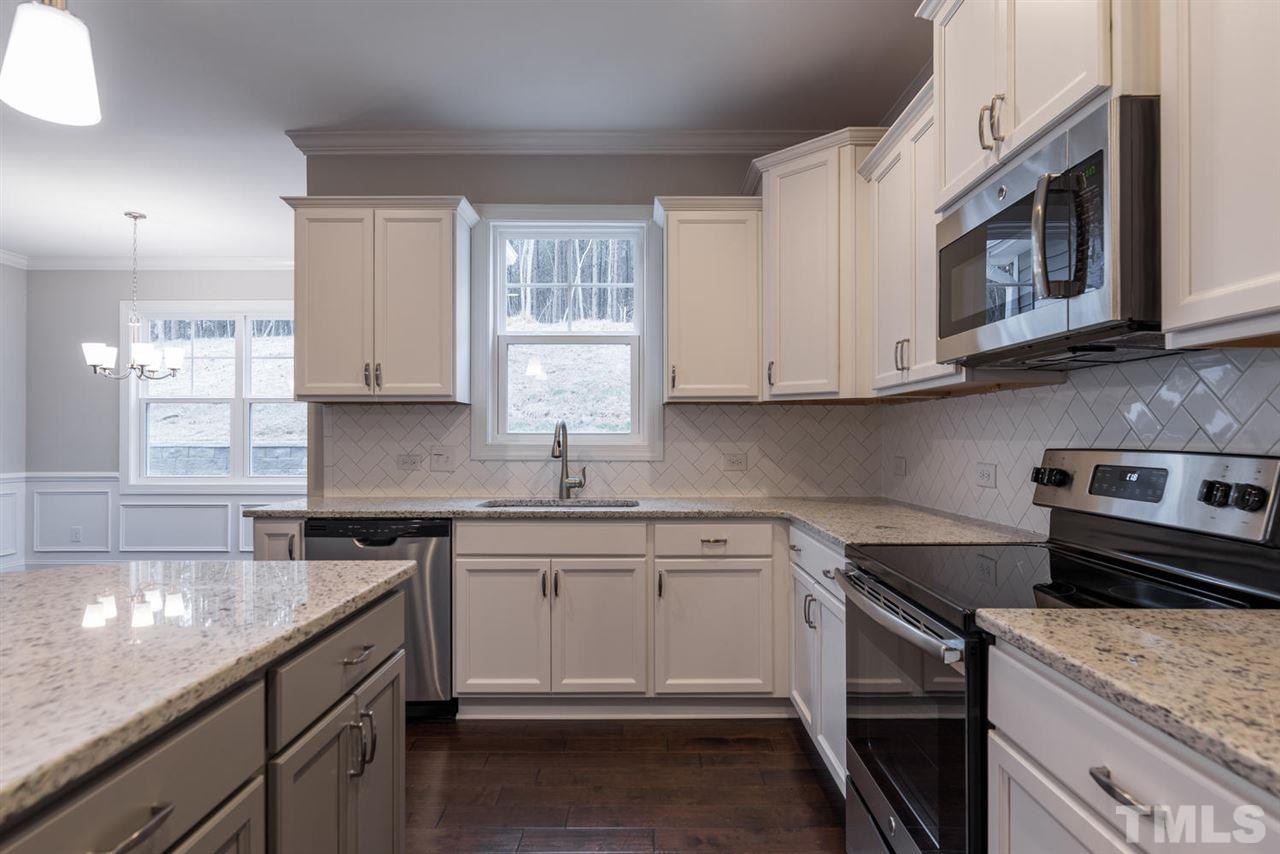 57 Ravencliff Ridge Garner, NC 27529 - Photo 11 of 25 a kitchen with stainless steel appliances granite countertop a sink stove and microwave